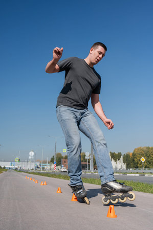 A Caucasian man rollerblades around the slalom course