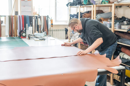 Bearded man working as a tanner in a workshop