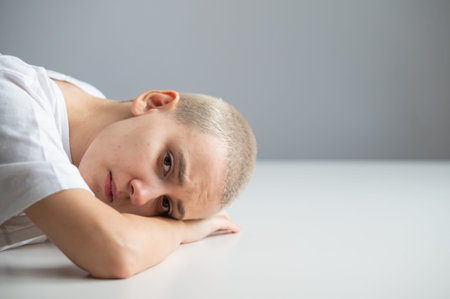 Sad woman with her head on the table on a white background
