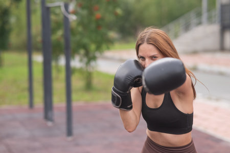 A Caucasian woman practices boxing outdoors