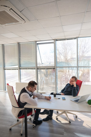 Two Caucasian men negotiating in an office