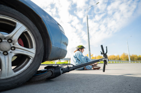A Caucasian woman on a scooter after being hit by a carの写真素材