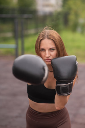 A Caucasian woman practices boxing outdoorsの写真素材