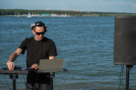 Caucasian man works as a DJ on the beachの写真素材