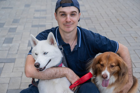 A man hugs his two dogs while on a walk