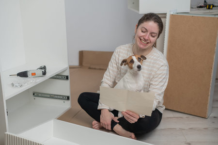 A Caucasian woman assembles furniture with her cute dog