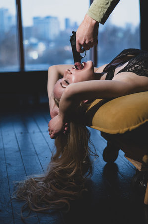 A woman lies with a gun in her mouth. Role-playing games