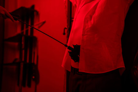 A man chains a woman's legs to a crossの写真素材