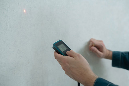 The master uses a laser tape measure