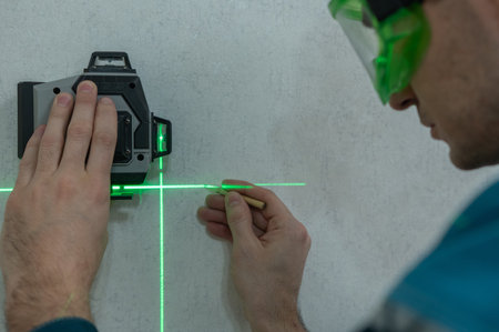 A man measures distance with a laser level