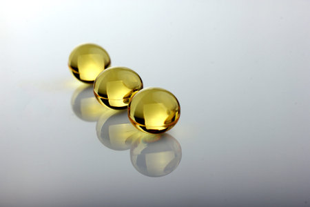 vitamin capsules on white table with reflectionの写真素材