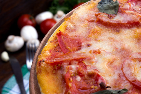 Margarita pizza with cheese and tomatoes on a wooden table