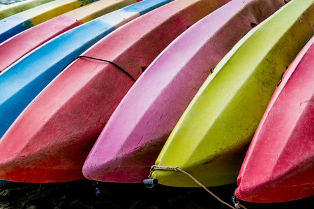 colorful kayaks lay down on the beachの写真素材