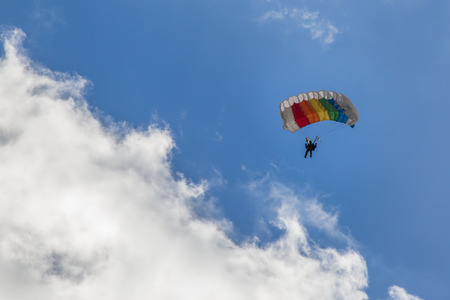 Parachuting, skydiver descends by parachute through the cloudsの写真素材