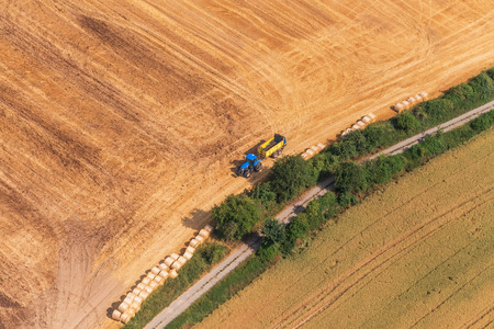 Aerial view of field and tractor with sidingの写真素材