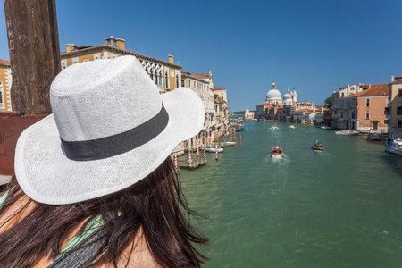 Traveling. Tourist in hat watching the Grand Canal in Venice, Italyの写真素材