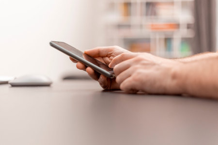 Close up view of hand with mobile phone. Work with the cell phone. Working from home, home office