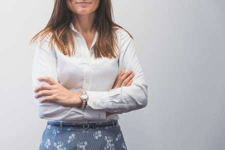 Business woman standing with arms crossed, front viewの写真素材