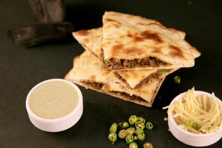 Smoked Minced Meat Stuffed Naan with Green Chillies on Black background with Coal