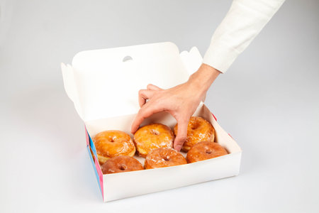 Donut packaging mock up template with hand holding a plain glazed donut.の写真素材
