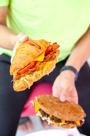 Brioche croissant grilled chicken sandwich in two hands lifestyle food photography.の写真素材