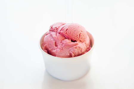 Strawberry gelato ice cream in a paper cup with plastic transparent spoon.の写真素材