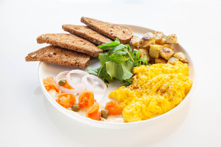 Smoked salmon with dill cream, capers and scrambled eggsの写真素材