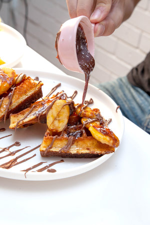 Chocolate waffle with dressing of chocolate sauce and strawberry gelato on the side.の写真素材