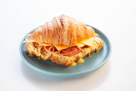 Brioche croissant chicken sandwich on a blue plate white background.の写真素材