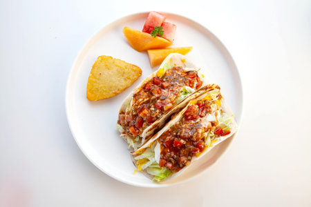 Soft shell delicious tacos for breakfast with hash brown and seasonal fruits top angle.の写真素材