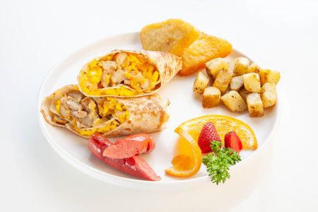 Tortilla wrap scrambled eggs with sausage hash brown potatoes and fruits.の写真素材