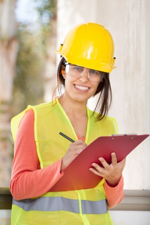 Woman holding a notepad and writing at work in a constructionの写真素材