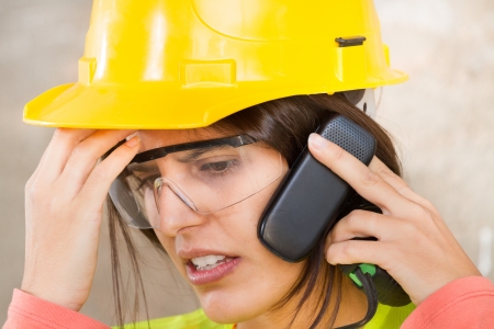 Portrait of a woman with safety helmet and mobile phone の写真素材
