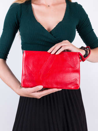 Young woman with a red clutch bag made of genuine leatherの写真素材