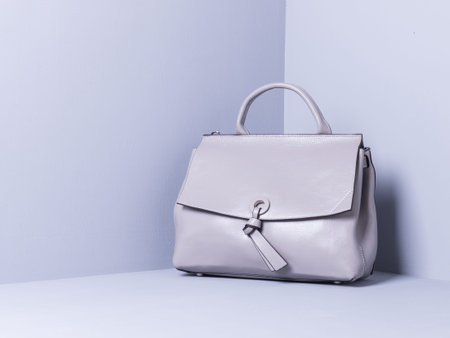 Women's bag of gray color, genuine leather. Gray painted wooden background. Space for textの写真素材