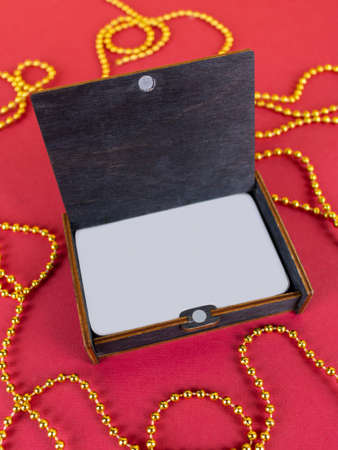 Board game, cards in a gift wooden box. On a red background with gold beadsの写真素材