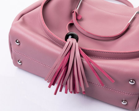 The bottom of the bag pink color. A handbag with metal fittings and a tassel with a black acrylic beadの写真素材