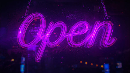Neon sign with word open hanging on the glass, night city backgroundの素材