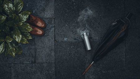 Flat lay composition with an umbrella and a cigarette on a stone backgroundの素材