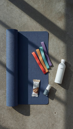 Top view of blue yoga mat with lotion bottle on concrete floorの素材