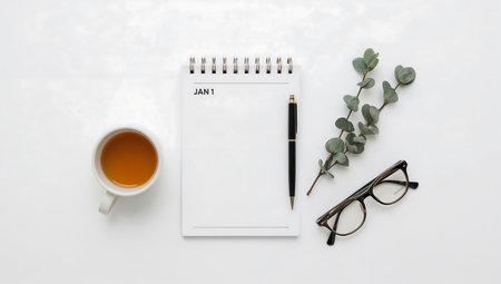 Notebook, pen, glasses, eucalyptus and a cup of tea on a white backgroundの素材