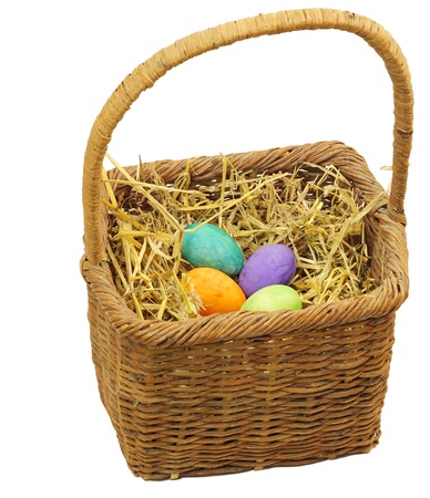 A rustic Easter basket with colorful eggs isolated on whiteの写真素材