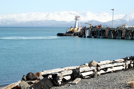 Tug boat moving past the ferry dock on a sunny day at the harbor in Homer Alaskaの写真素材