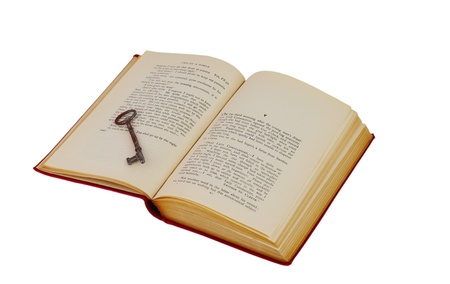Reading is the key: Antique book with an old key isolated on whiteの写真素材