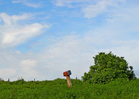 An old rusty mailbox in a green fieldの写真素材