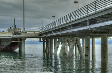 Commercial shipping dock in an industrial area of Homer, Alaska with storm cloudsの写真素材