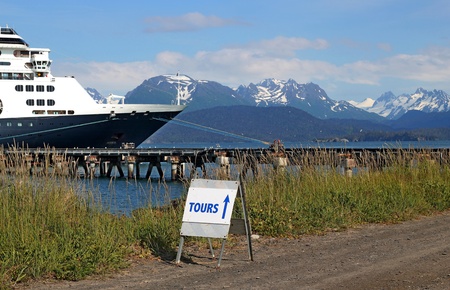 Tour sign for cruise ship passengers with the cruise ship in the background in Homer, Alaska on a sunny day.のeditorial素材