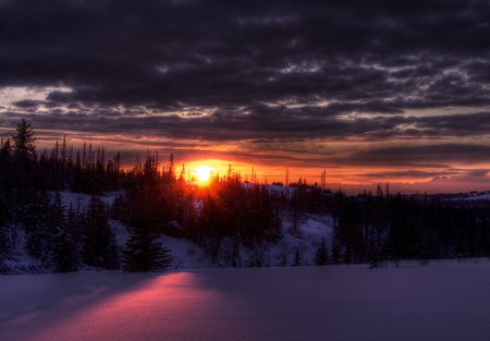 A dramatic Alaskan winter sunset with dark clouds.の写真素材