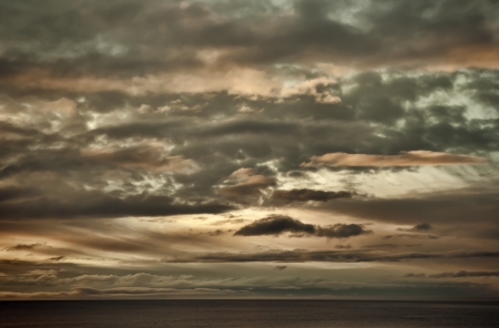 Interesting clouds at sunset over a calm sea.の写真素材