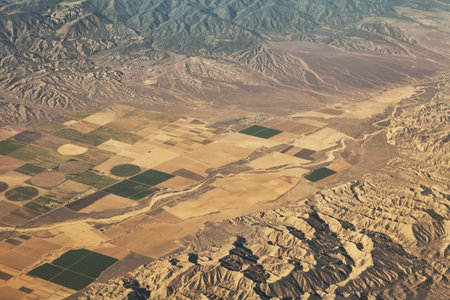 Aerial view of California farms surrounded by mountains.